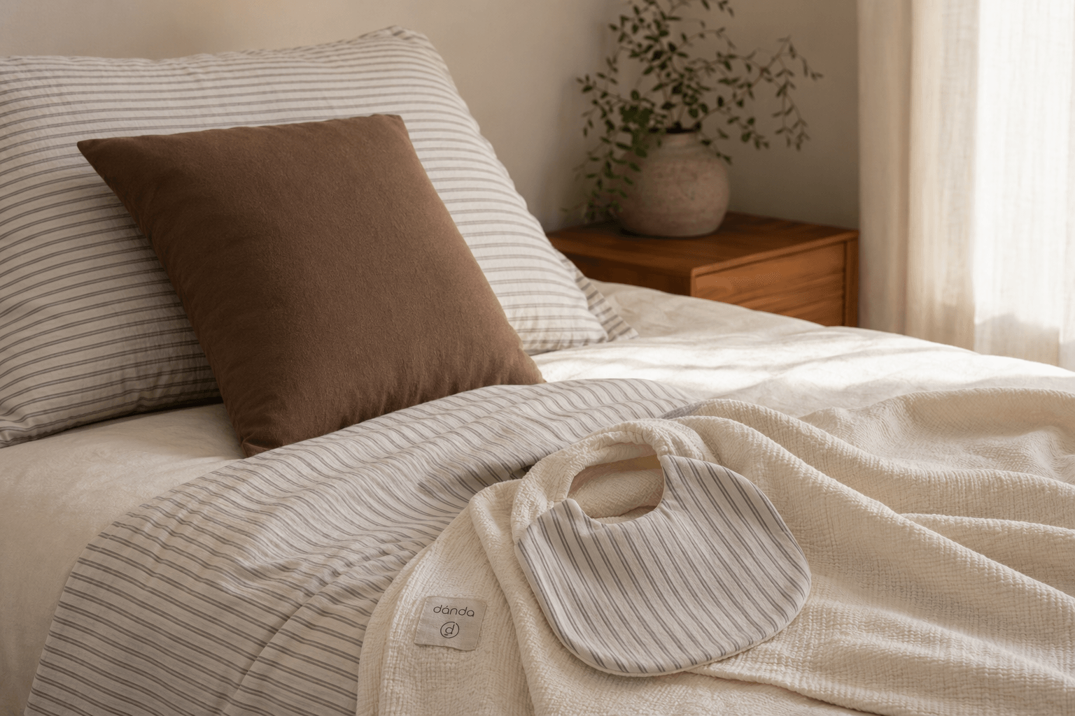 A soft blanket and bib resting together in warm natural light.