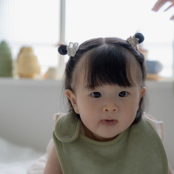 Parents folding soft baby textiles in a calm home setting.